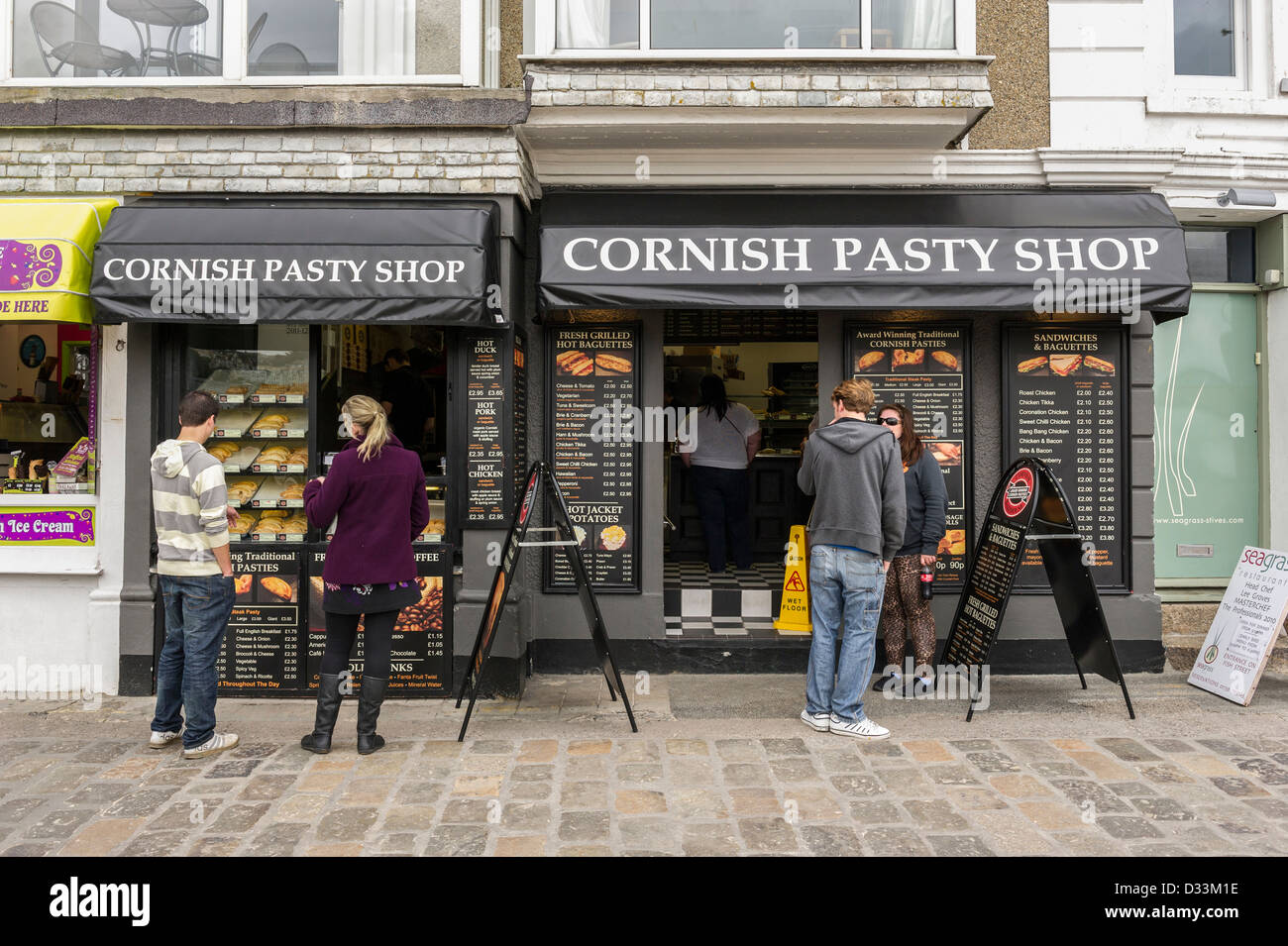 I clienti al di fuori del Cornish pasty shop in St Ives, Cornwall, Regno Unito Foto Stock