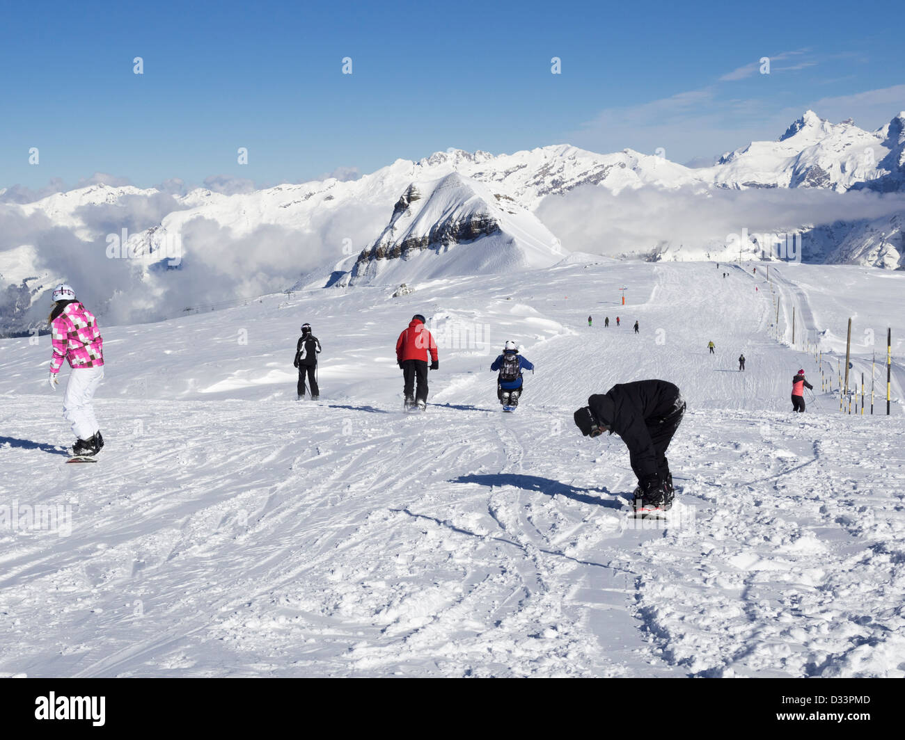 Gli appassionati di snowboard snowboard blu pendio di neve piste a serpentina su Les Grandes Platieres in Le Grand Massif ski area delle Alpi francesi. Flaine Francia Foto Stock