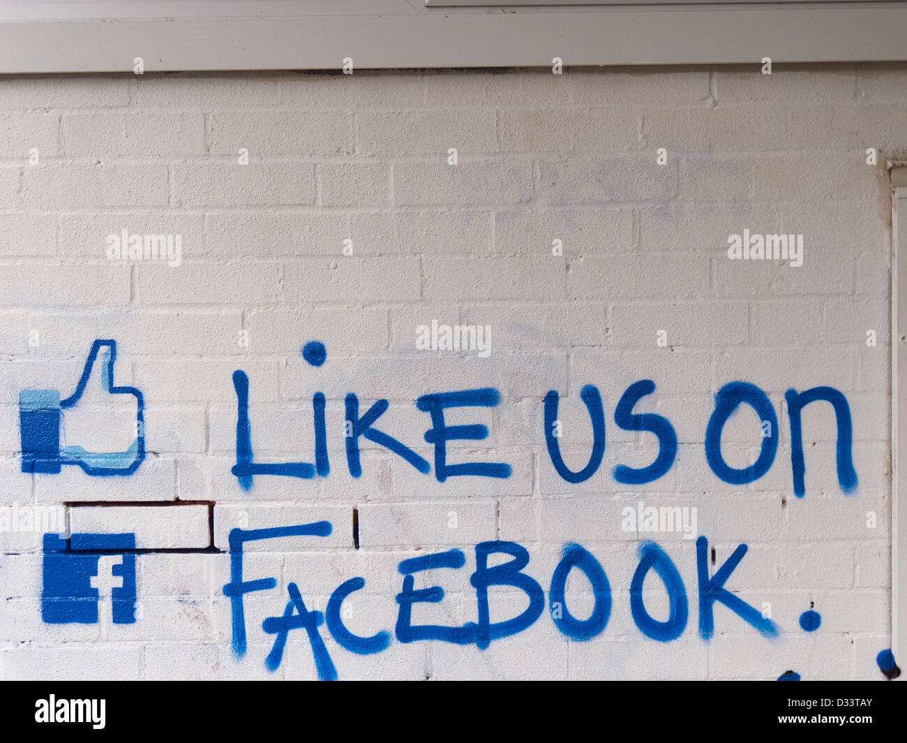 Come noi su facebook chiamata all azione dipinta su un muro di mattoni. Foto Stock