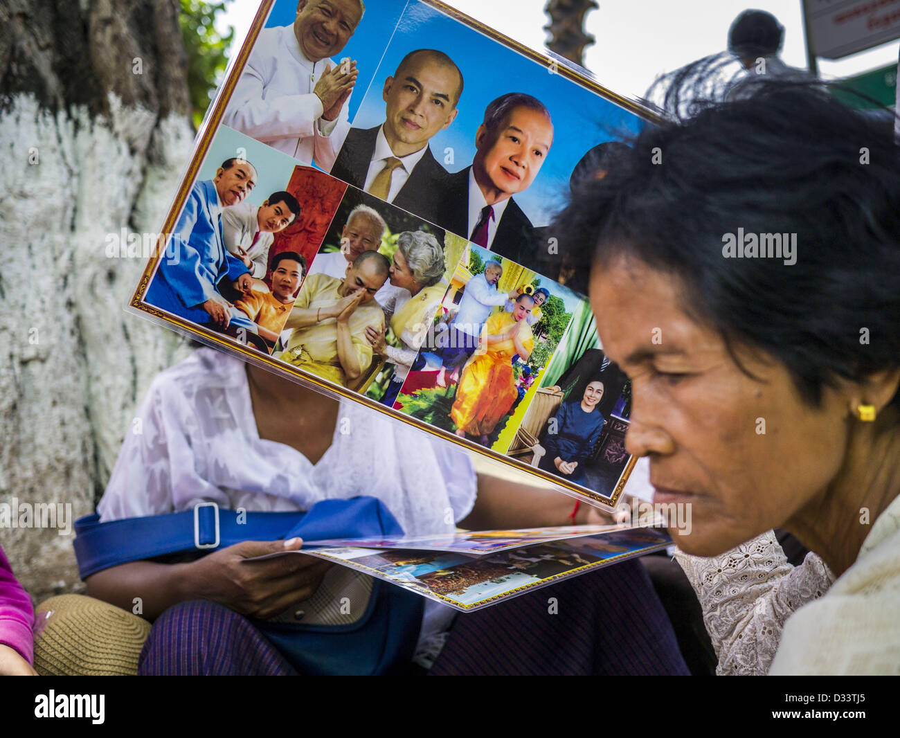 Febbraio 2, 2013 - Phnom Penh Cambogia - Una donna conserva le foto del defunto re Norodom Sihanouk durante il periodo del lutto per Sihanouk, che hanno governato la Cambogia, dall'indipendenza nel 1953 fino a che egli è stato rovesciato da un golpe militare nel 1970. Sihanouk è morto a Pechino, in Cina, in ottobre 2012. (Credito Immagine: © Jack Kurtz/ZUMAPRESS.com) Foto Stock