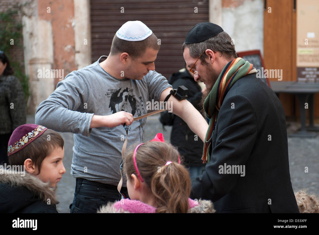 Uomo ebraico si prepara a pregare con tallit e Tefillin al Ghetto di Roma. Foto Stock