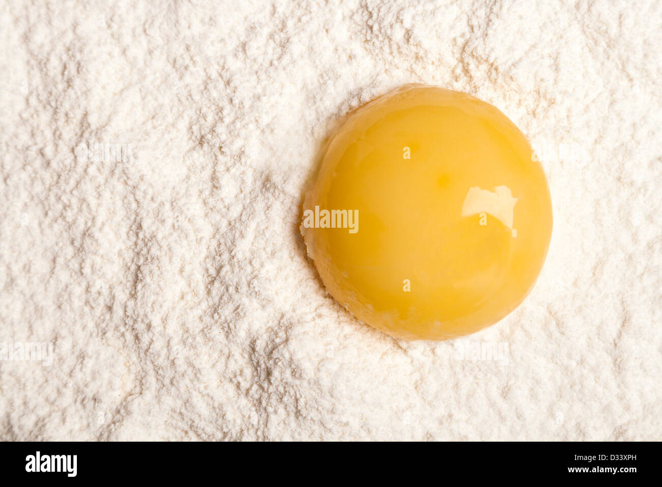 Tuorlo d'uovo nella farina bianca con ombra Foto Stock