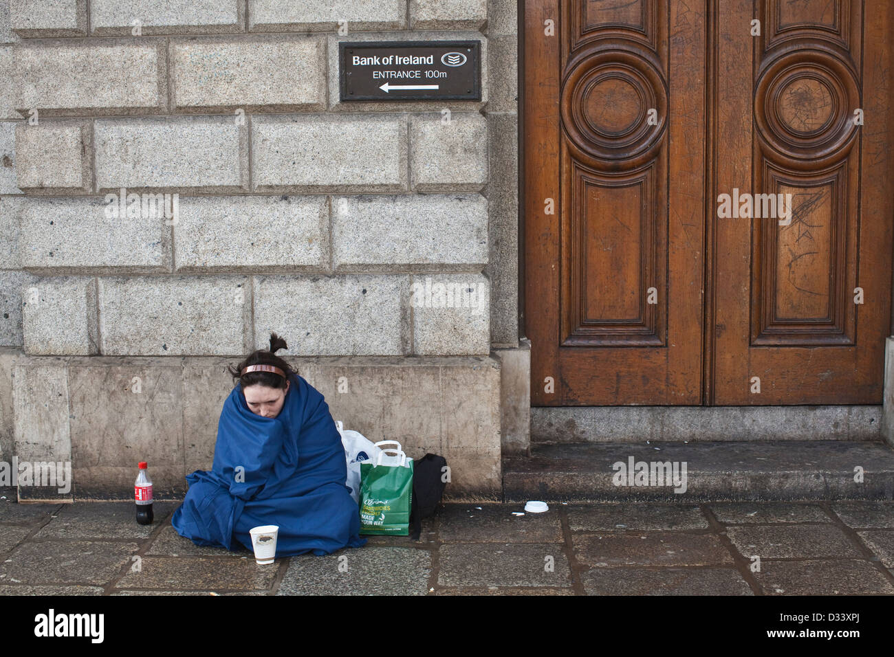 Donna senzatetto elemosinare sulla soglia della Bank of Ireland, Westmoreland Street, Dublin, Irlanda. Foto Stock