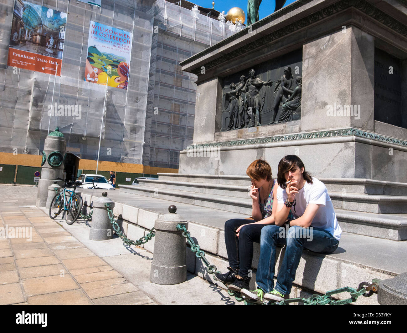 Il giovane e la ragazza Sigaretta fumare sotto una statua Foto Stock