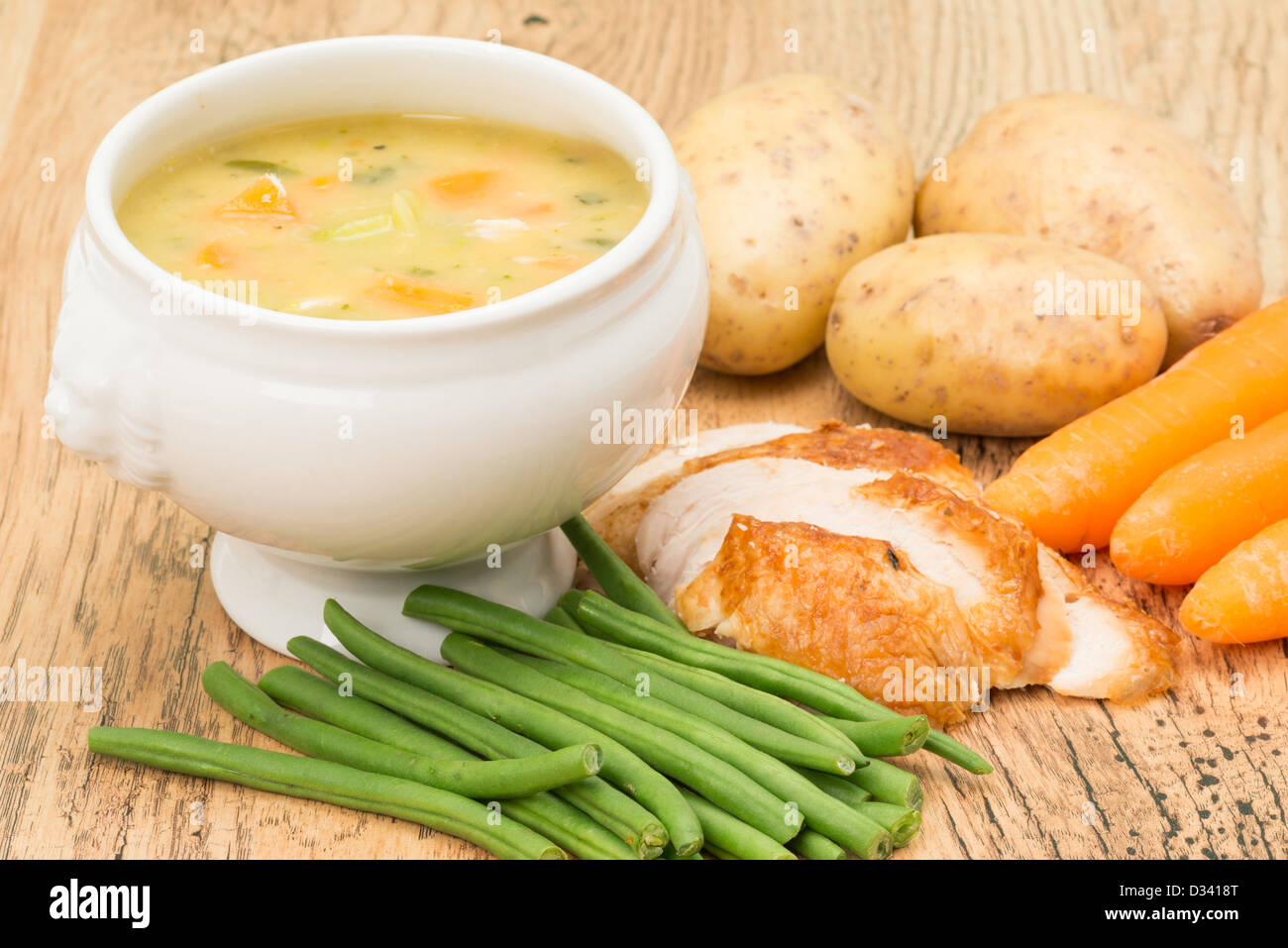 Il pollo e la minestra di verdura con alcuni ingredienti, carote, patate, fagioli verdi e le fette di pollo Foto Stock