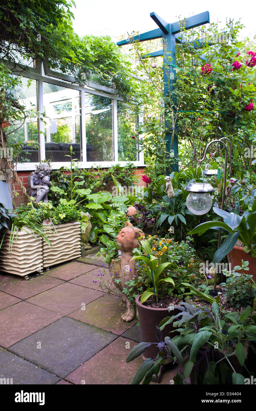 Il patio in piccole città giardino pieno di piante in vaso e ornamenti. Foto Stock