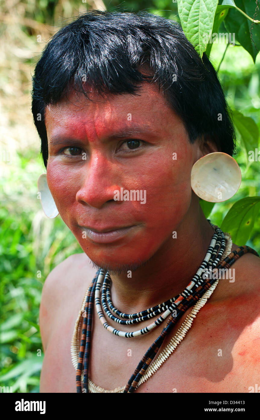 Un giovane uomo matis con tatuaggi facciali, gusci a suoi orecchi, vernice rossa (achiote) e le tradizionali collane, brasil Foto Stock