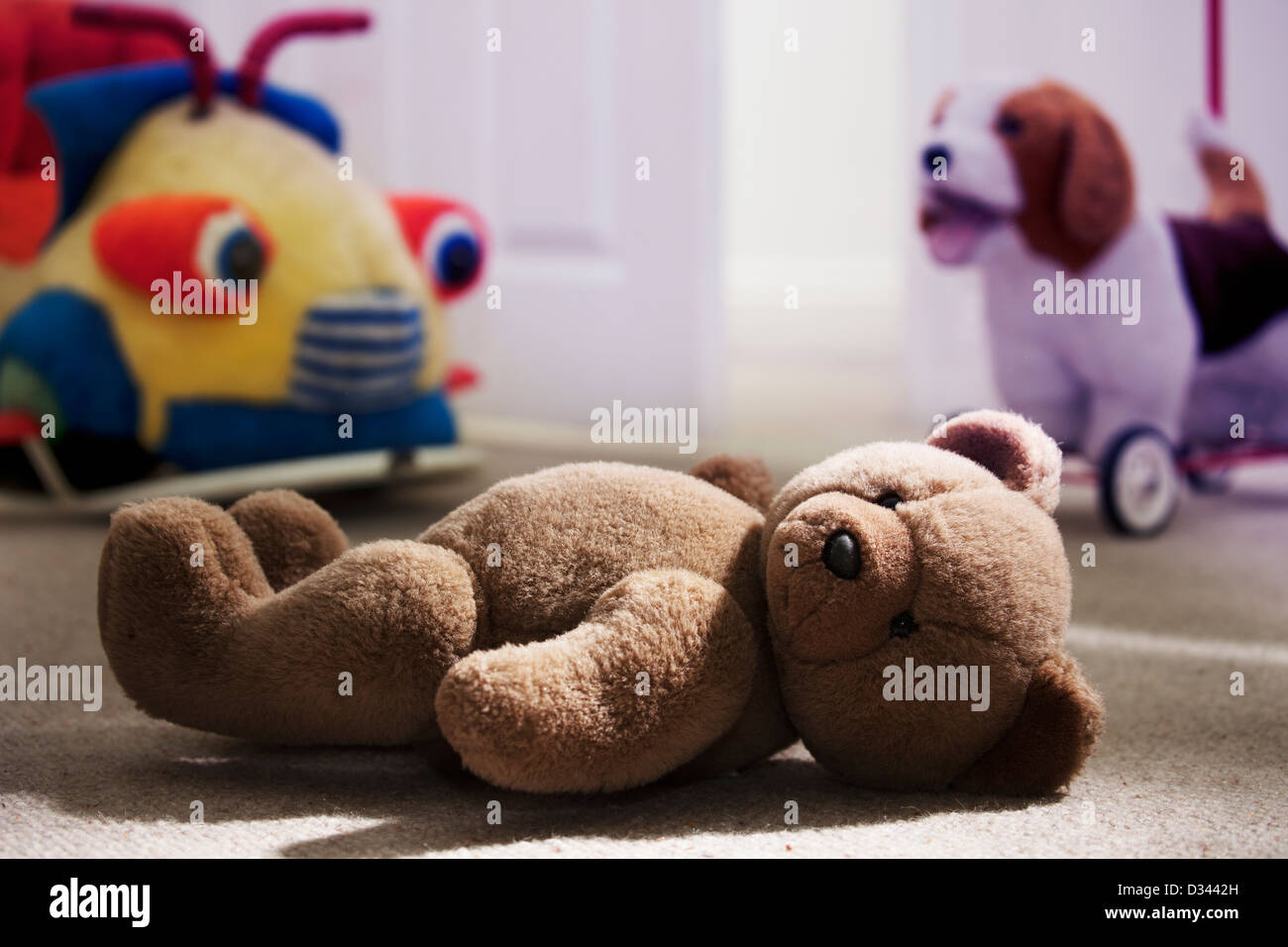 Brown orsacchiotto posa su un bambino il pavimento della camera. Foto Stock