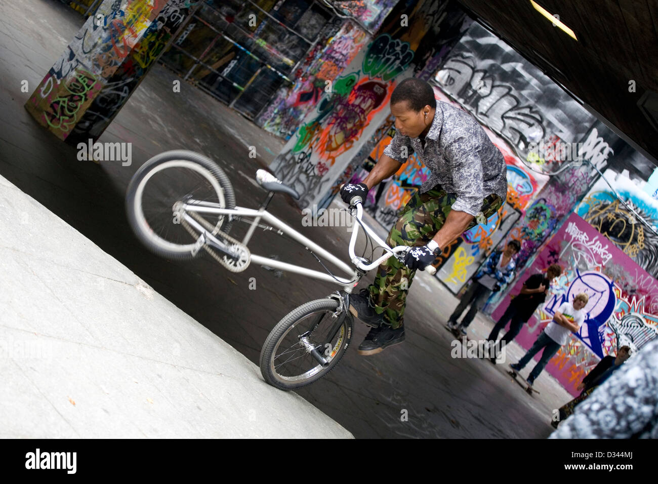 I giovani adulti su biciclette BMX e skateboard eseguire trick a Londra dal  Tamigi Foto stock - Alamy