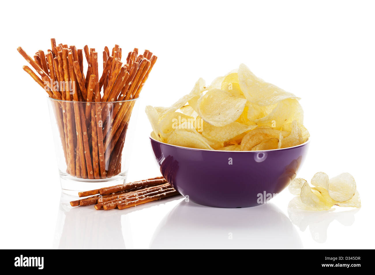 Patate fritte in una ciotola con il pretzel bastoni in un bicchiere su sfondo bianco Foto Stock