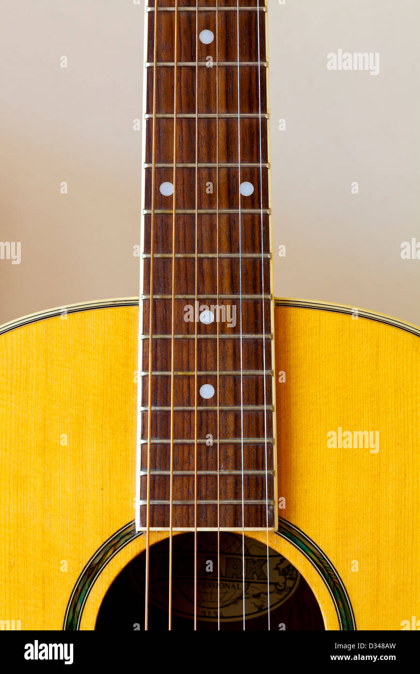 Dettaglio delle sei corde della chitarra acustica che mostra parte del collo con la tastiera e le stringhe e il foro Foto Stock