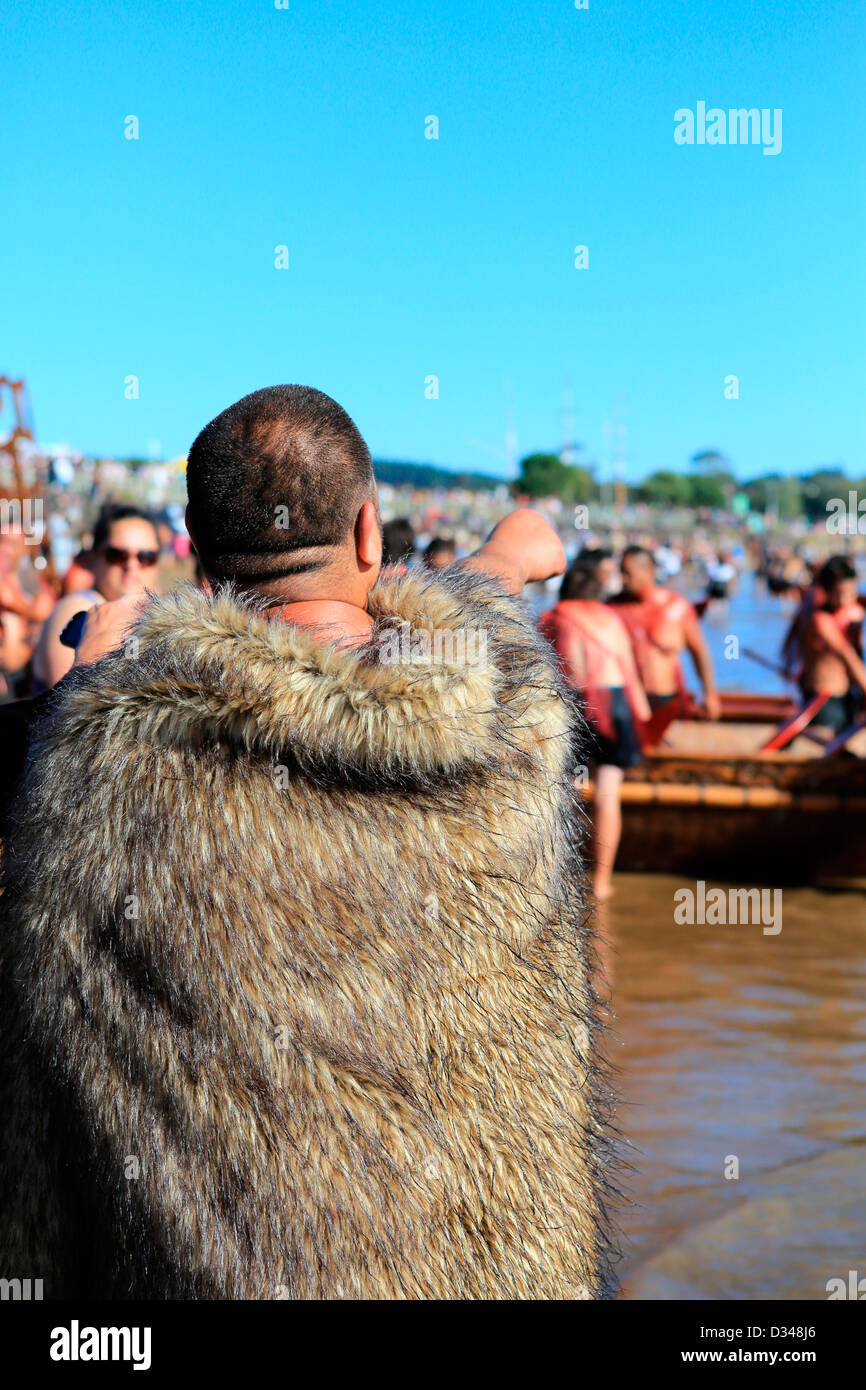 Uomo Maori in tradizionale feathered mantello il Te Tii beach durante Waitangi alle celebrazioni del Giorno Foto Stock