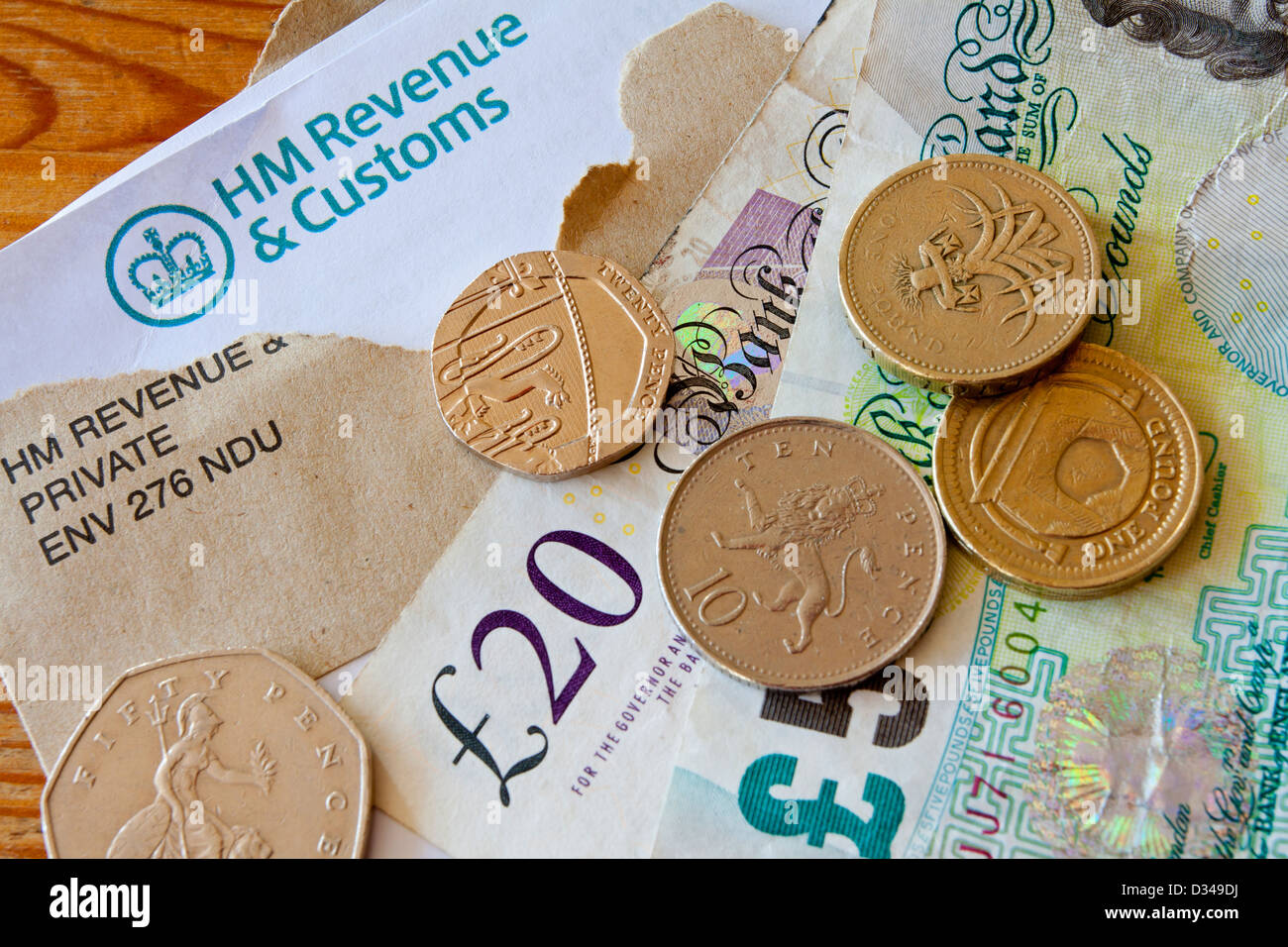 Regno Unito HM Revenue e dogana self assessment estratto fiscale lettera con busta marrone e contanti in banconote e monete Foto Stock