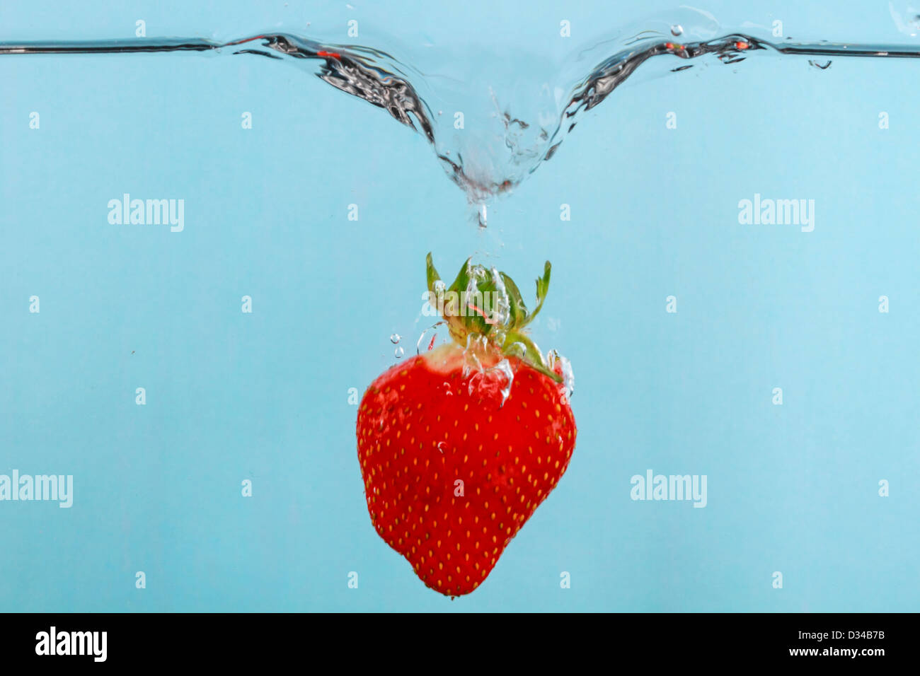 Fragola cadere in acqua con fotografia stop motion per catturare l'azione Foto Stock