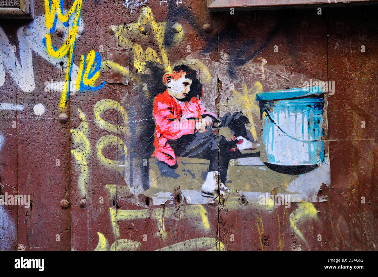 Barcellona, in Catalogna, Spagna. Stampata Graffiti. Ragazzo seduto accanto a bidone della spazzatura Foto Stock