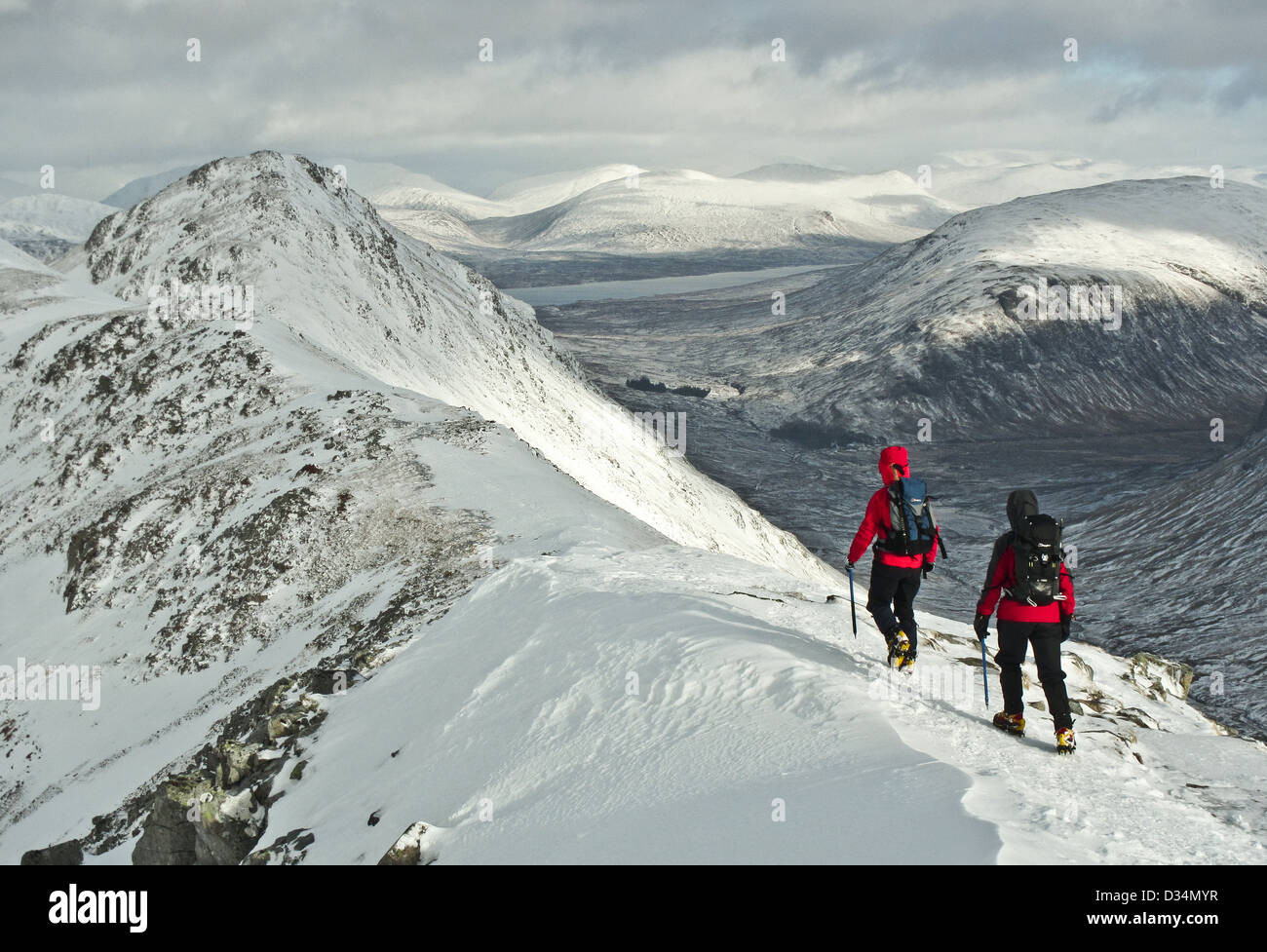 Due alpinisti invernali sulla montagna scozzese Buachaille Etive Beag in Glencoe nelle Highlands scozzesi, Scotland Regno Unito Foto Stock