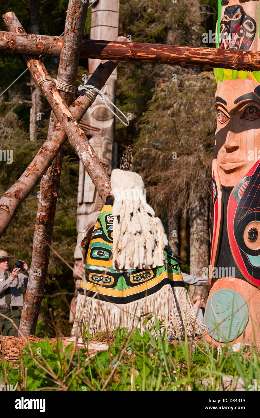 Local Tlingit e Kiksadi Clan vestito in regalia in totem pole il sollevamento per contrassegnare il centenario del Sitka National Park Foto Stock