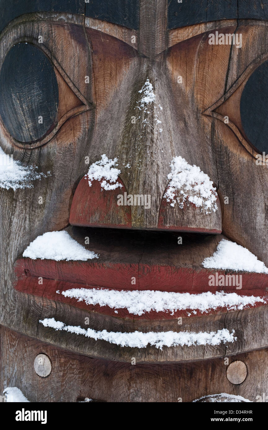 Vista ravvicinata di totem pole con neve in Sitka National Historical Park di Sitka, Alaska, Stati Uniti d'America. Foto Stock