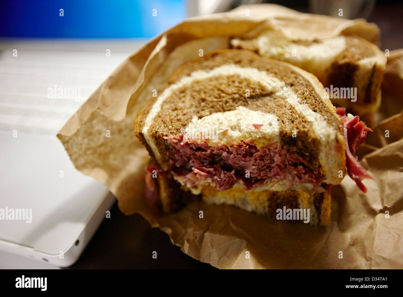 " Corned beef " Ruben sandwich per il pranzo accanto al computer portatile per il Nord America Foto Stock