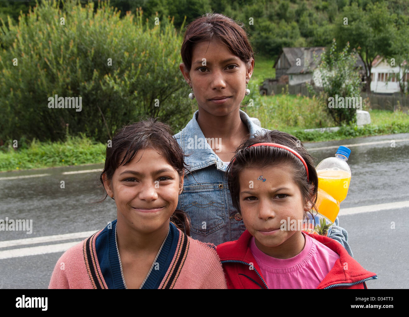 Tre unidentified gipsy ragazze pongono al centro della strada su 10 Agosto 2008 in Transilvania, Romania. Foto Stock