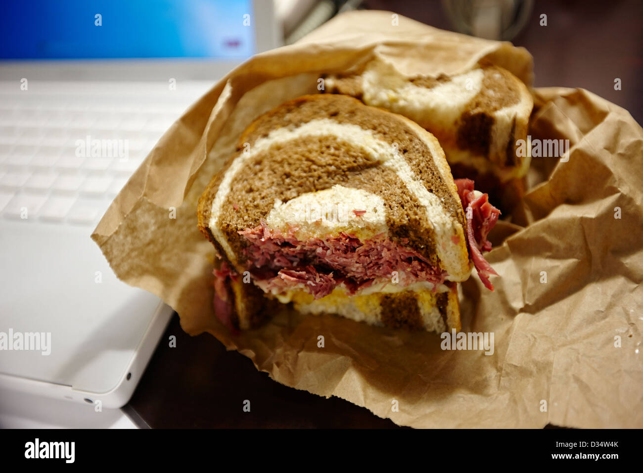 " Corned beef " Ruben sandwich per il pranzo accanto al computer portatile per il Nord America Foto Stock