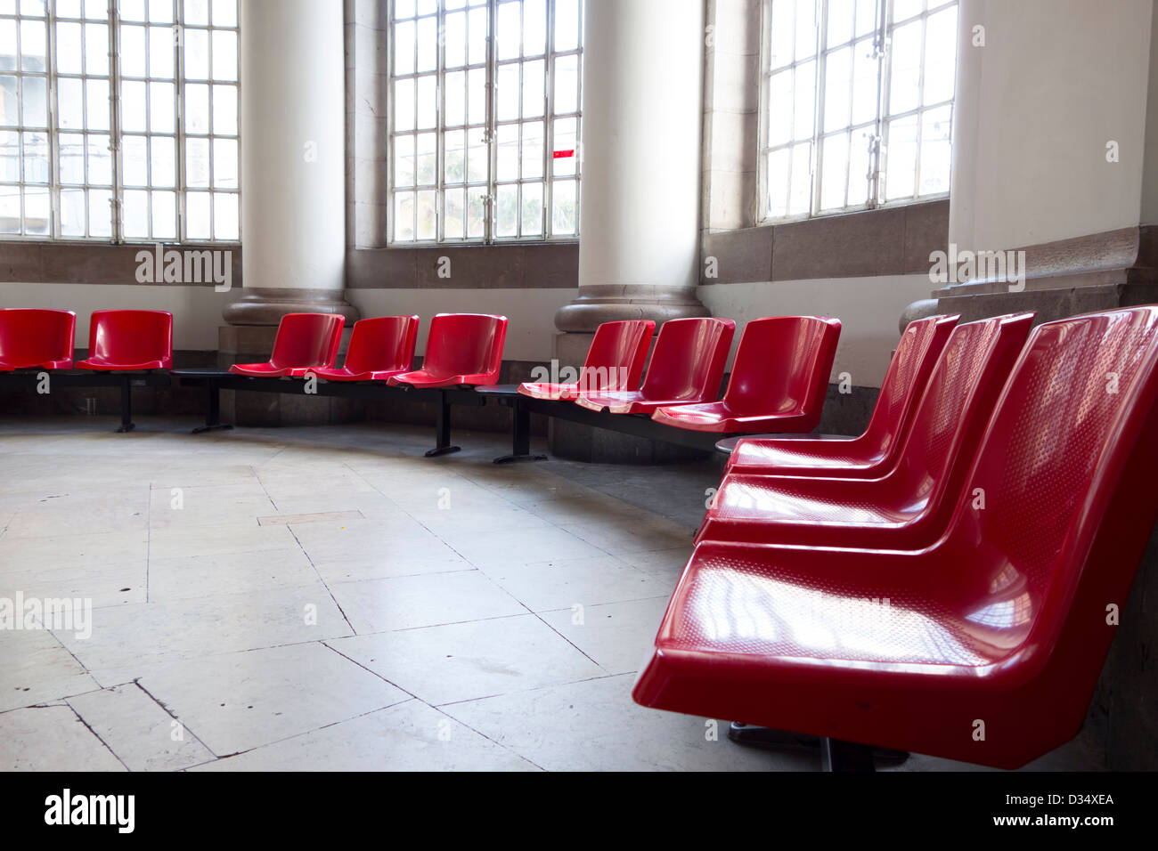 Svuotare il salotto con sedie rosse e grandi finestre Foto Stock