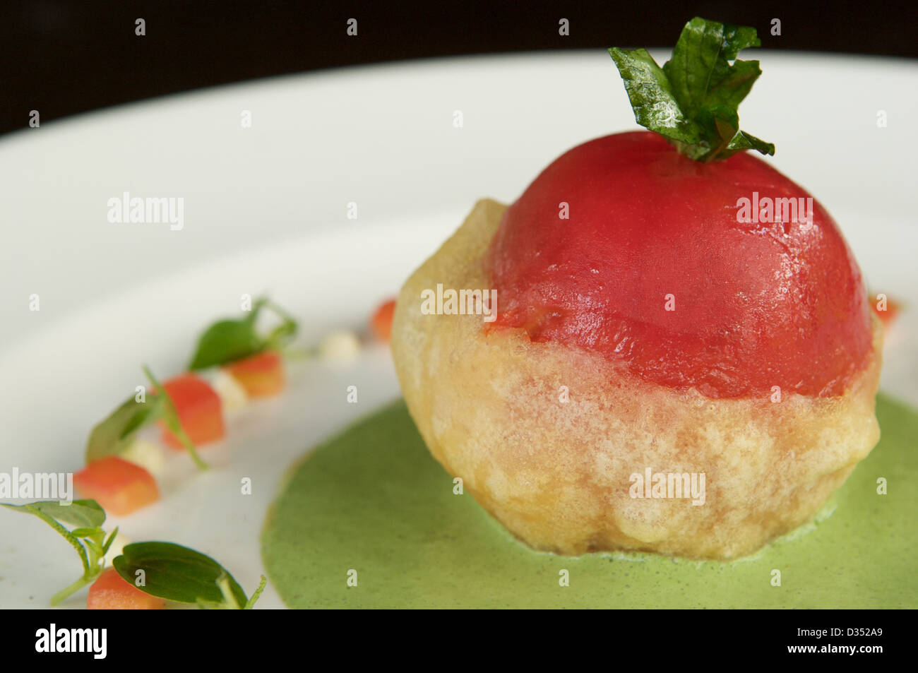 Tempura ripiene di pomodoro organico con il granturco dolce, la crema di formaggio, basilico e purea di Avocado servito su una piastra bianca. Foto Stock