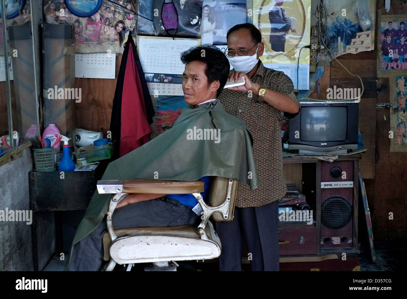 Barbiere Thailandia con attrezzature d'epoca e layout nel centro di Bangkok con uomo che riceve un taglio di capelli. Thailandia, S. E. Asia Foto Stock