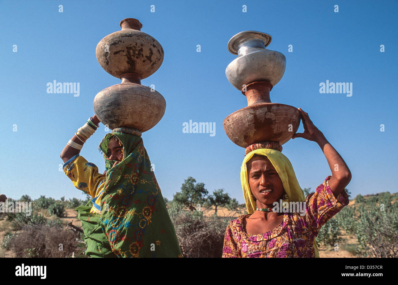 Madre e figlia che trasportano acqua di casa sulle loro teste da un pozzo lontano. Vicino a Islamakot, il deserto di Tharparkar. Pakistan Foto Stock
