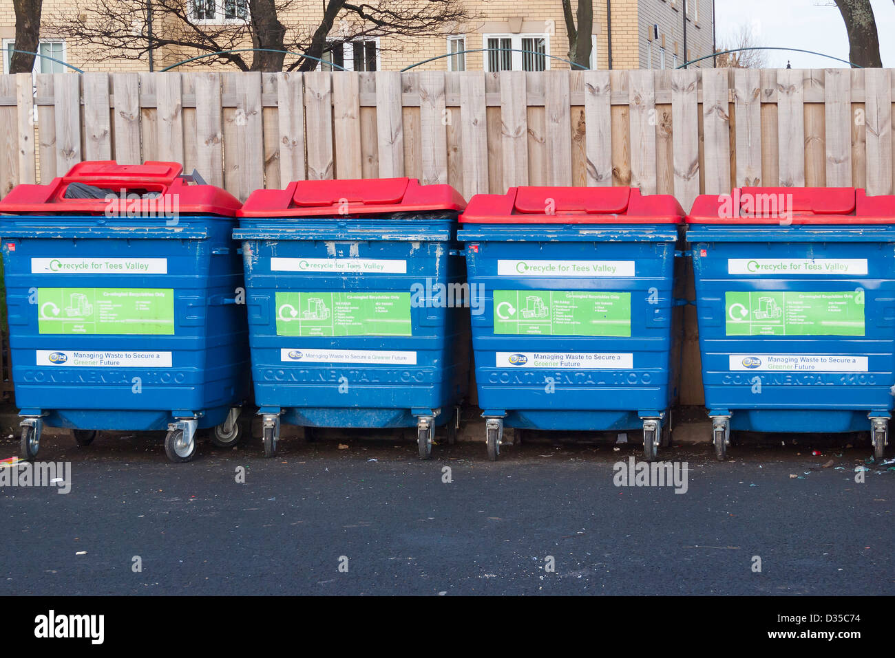 Quattro identici contenitori di riciclaggio per co-mescolato i rifiuti di carta e cartone di bottiglie in plastica Foto Stock