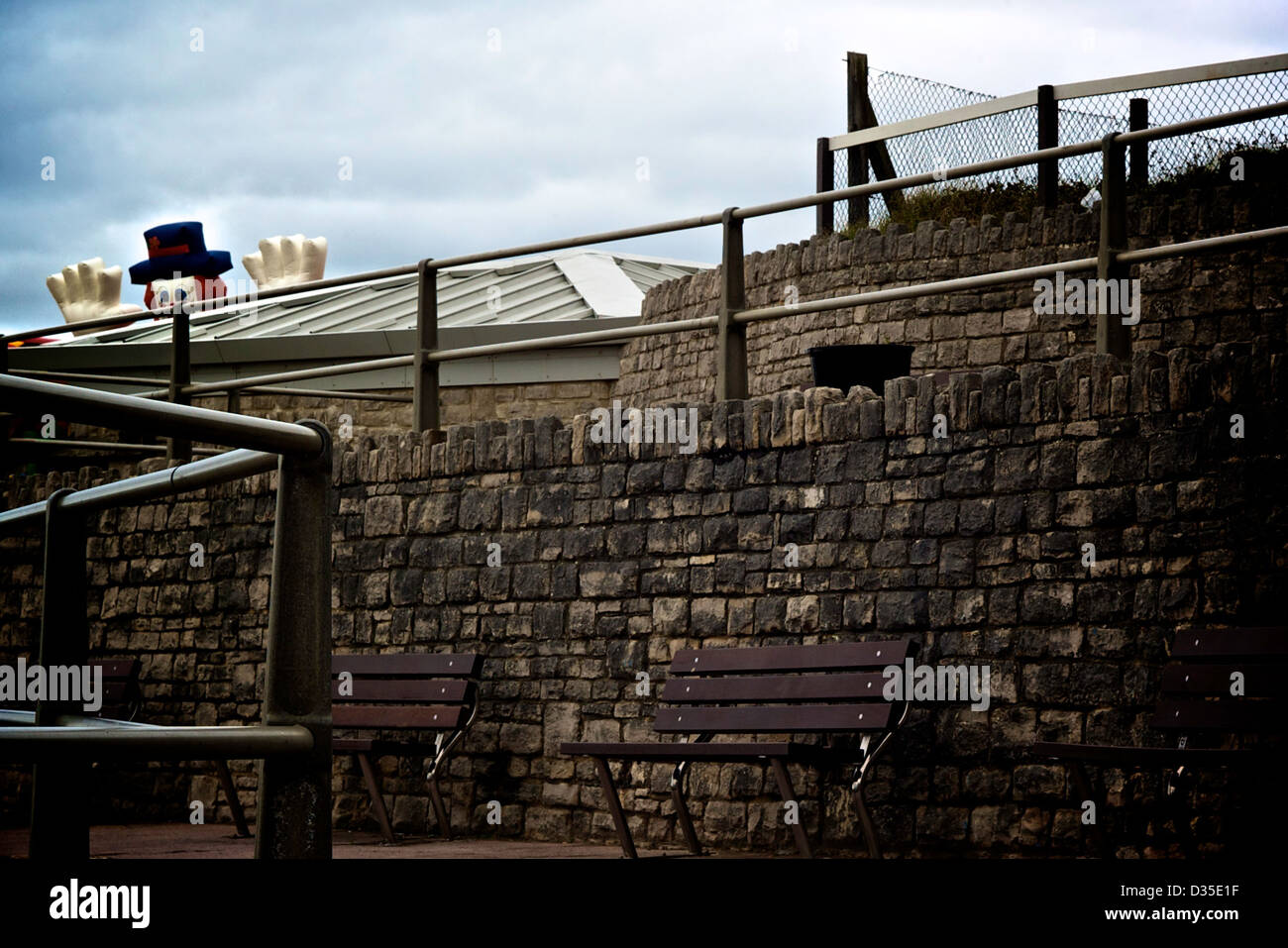 Uomo gonfiabile guardando sopra un tetto e parete da Bournemouth Beach. Foto Stock
