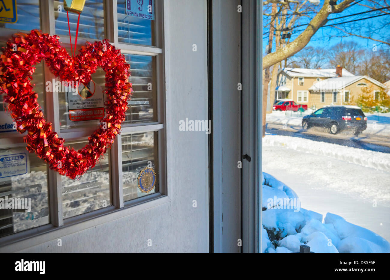 Febbraio 9, 2013 - Merrick, New York, Stati Uniti - Dopo la bufera di neve Nemo hits Long Island South Shore europee, auto ride through viscido arata strade, come visto da davanti la porta di casa decorata con cuore rosso per il giorno di San Valentino che è a pochi giorni di distanza. Foto Stock