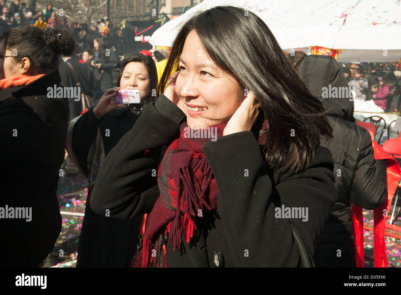 La città di New York, US, 10 febbraio 2013. Una giovane donna blocca i suoi orecchi contro il rumore dei petardi presso il nuovo anno lunare cinese petardo festival. Il rumore è creduto per guidare gli spiriti maligni. Foto Stock