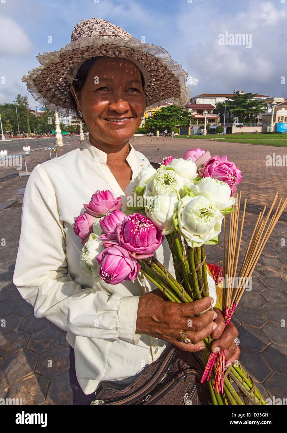 Giovane donna vendita di fiori di loto al di fuori del Palazzo Reale di Phnom Penh Cambogia. Foto Stock