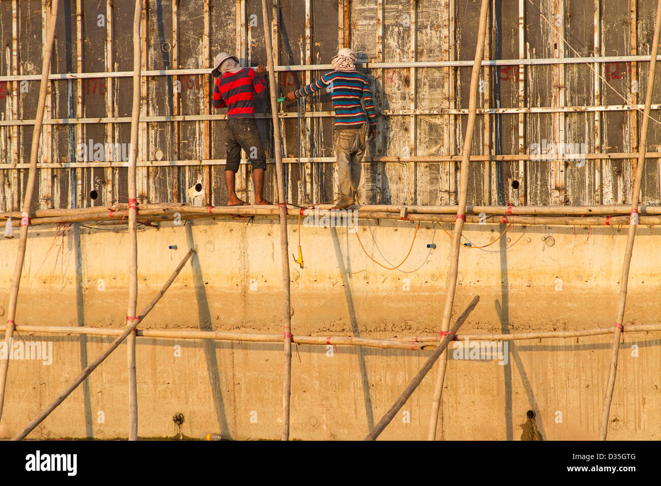 Lavoratori costruire extensiion per diga lungo il fiume Tonle Sap, Phnom Penh Cambogia. Foto Stock