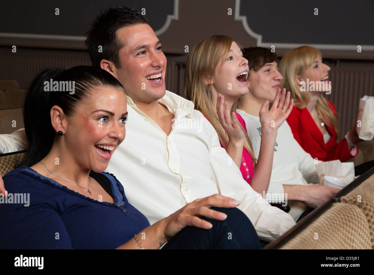 Ridere la gente in un cinema o teatro la visione di un filmato o di un gioco Foto Stock