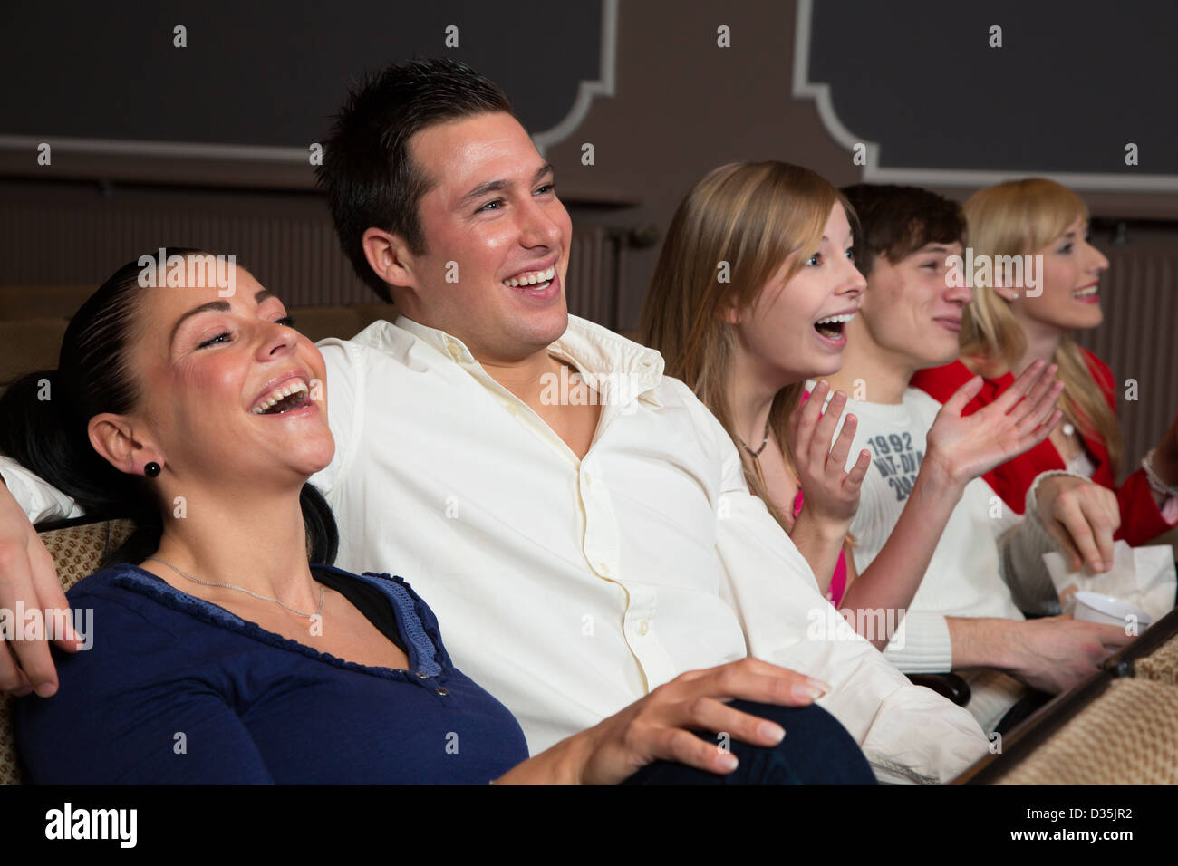 Ridere la gente in un cinema o teatro la visione di un filmato o di un gioco Foto Stock