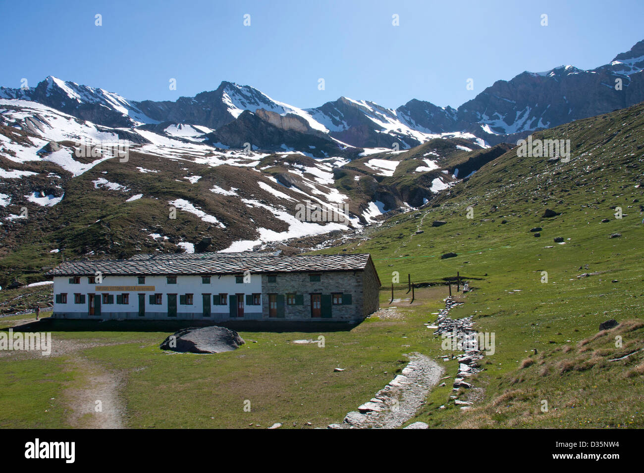 Rifugio Vittorio Sella cai sez Biella rotta 18 con neve picchi placcati in background, Valnontey, il Parco Nazionale del Gran Paradiso, Italia Foto Stock