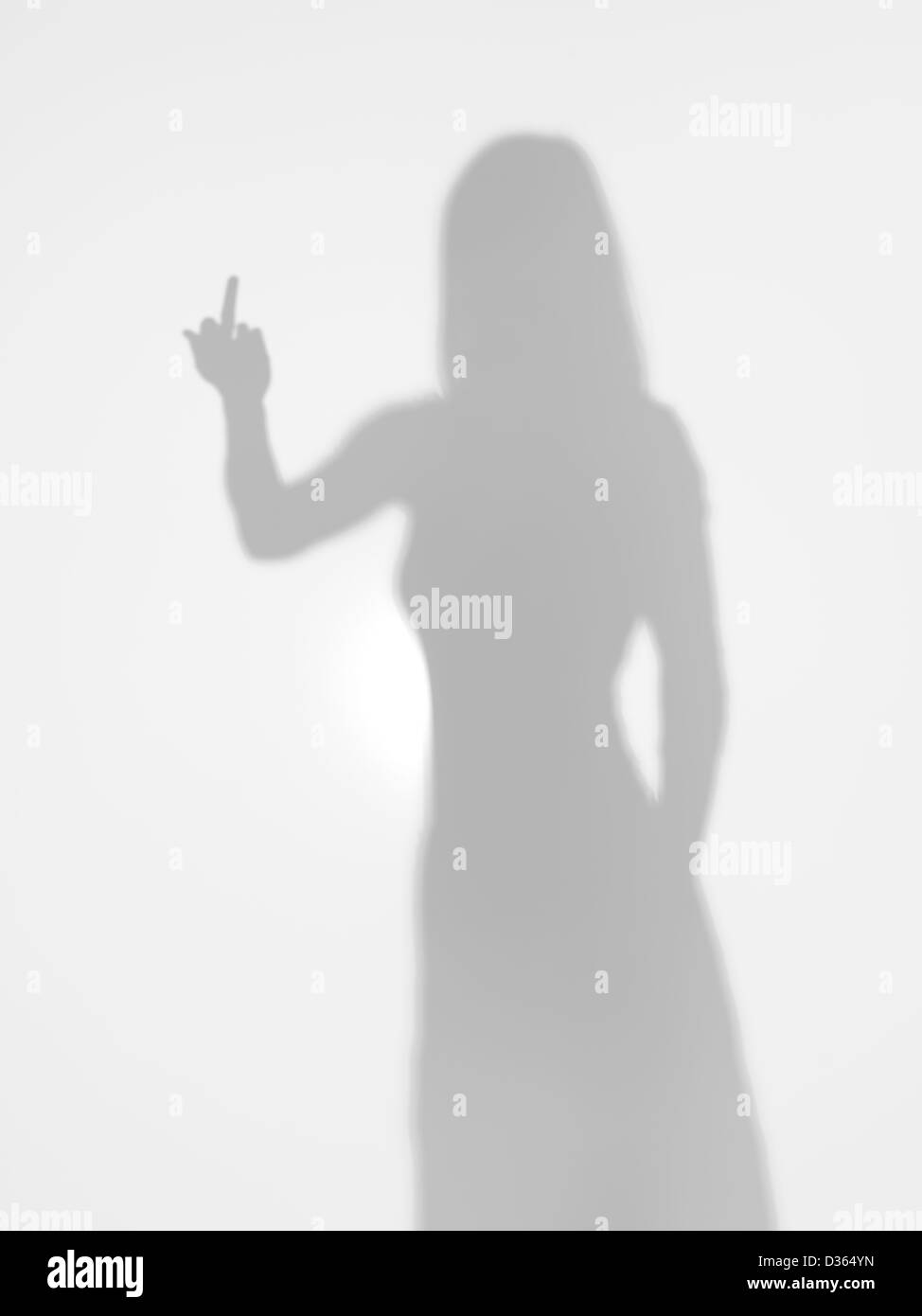 Corpo femmina silhouette che mostra il dito medio dietro una superficie diffusa Foto Stock