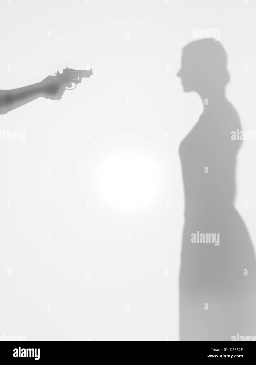 Corpo di donna silhouette standing, beeing thretened con una pistola, dietro una superficie diffusa Foto Stock