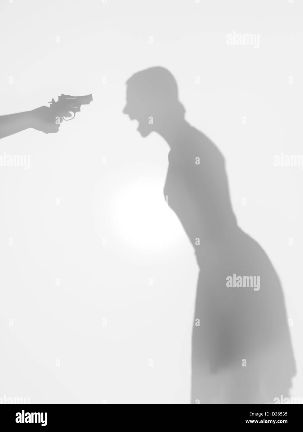 Corpo di donna silhouette in piedi e urlando, beeing thretened con una pistola, dietro una superficie diffusa Foto Stock