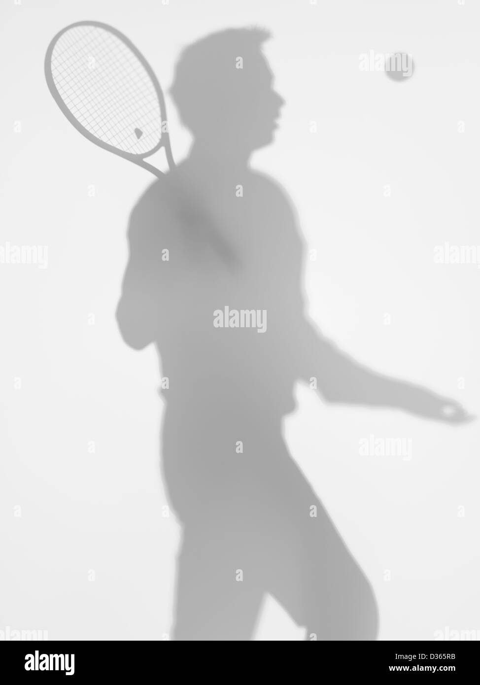 Vista laterale dell'uomo giocatore di tennis al servizio, dietro una superficie diffusa Foto Stock