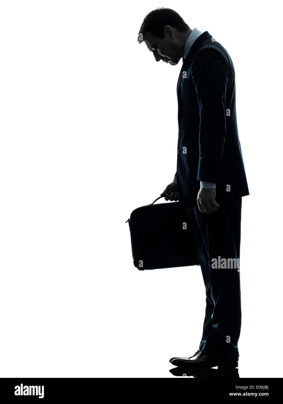 Una triste business man guardando giù in silhouette studio isolato su sfondo bianco Foto Stock