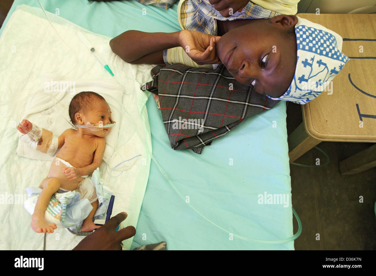 Carrefour, Haiti, una felice madre giace accanto al suo neonato in ospedale da campo Foto Stock