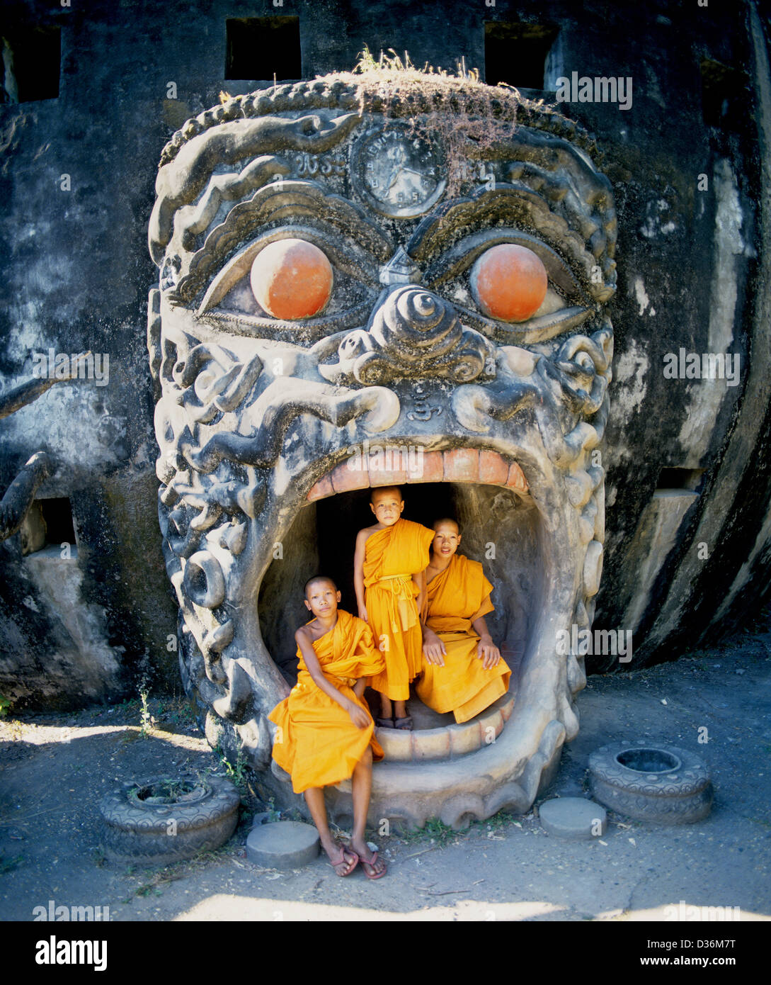 Laos, Vientiane, Buddha Park, monaco buddista novizi nel demone bocca della zucca gigante scultura a Wat Xieng Khuan Foto Stock