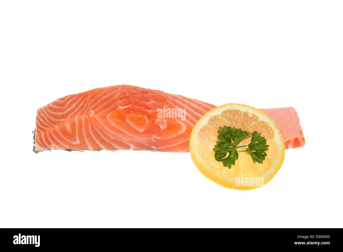Bistecca di salmone e una fetta di limone con il prezzemolo isolata contro bianco Foto Stock