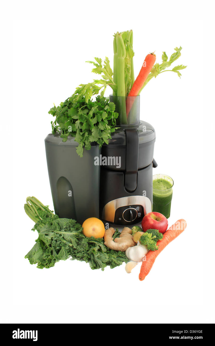 Spremiagrumi circondato da sani verdure come le carote e lo zenzero e i cavoli rapa con fresche fatte succo verde pronto da bere Foto Stock