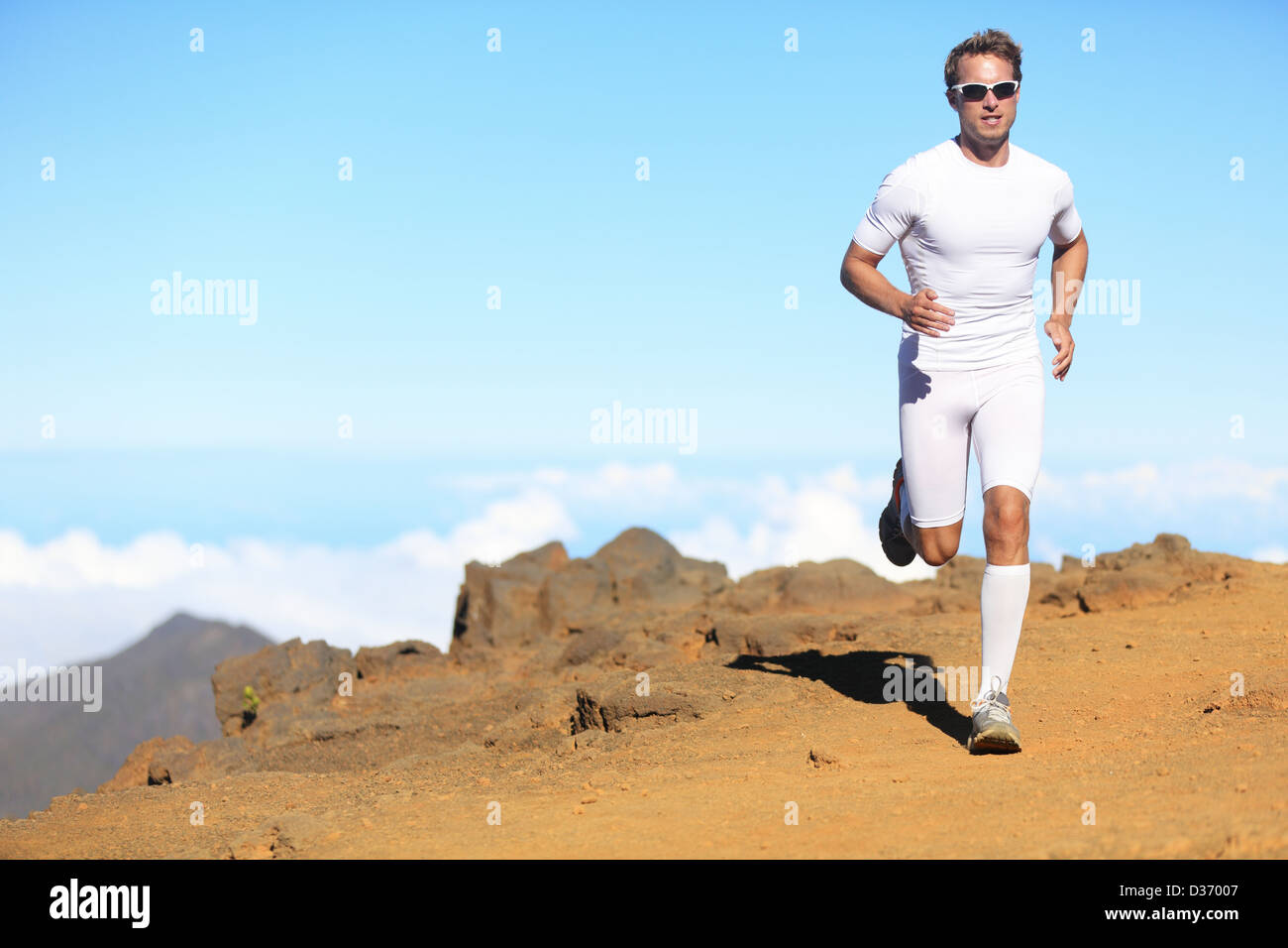 Lunghezza completa di sportivo atletica fit uomo in abbigliamento di compressione in esecuzione per la maratona Correre nel paesaggio panoramico Foto Stock