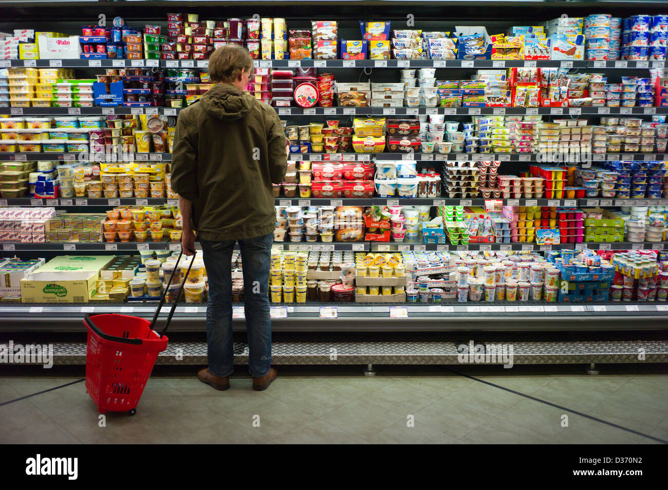 Berlino, Germania, un cliente di fronte a uno scaffale di supermercato con prodotti caseari Foto Stock