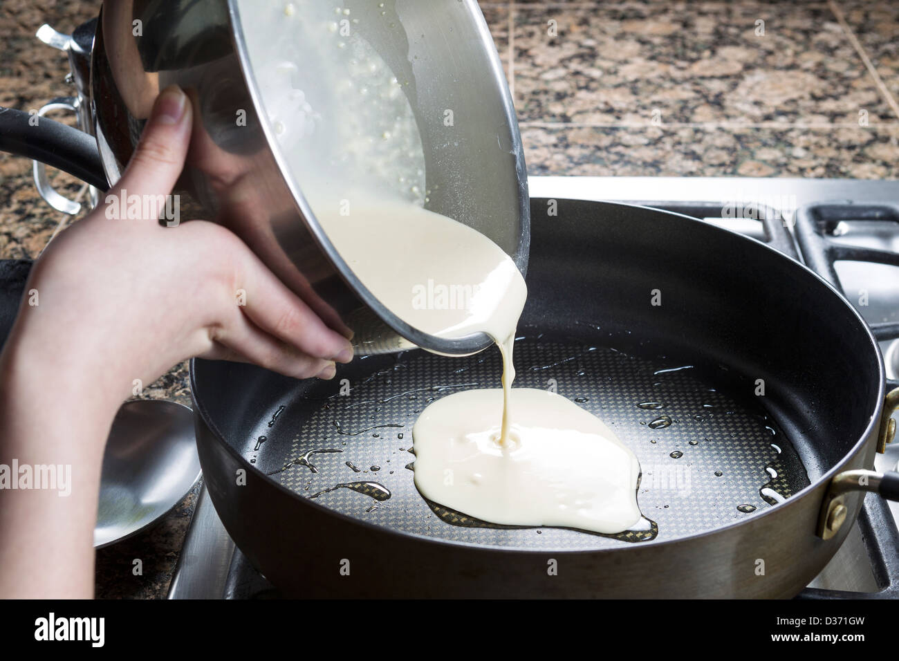 Foto orizzontale di concentrarsi sulla pastella di frittella dolce proveniente dalla vasca inox e in padella calda Foto Stock